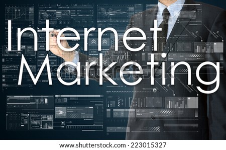 the businessman is writing Internet Marketing on the transparent board with some diagrams and infocharts with the dark elegant background