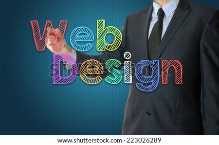 the businessman is writing Web Design with colorful font on the transparent board with some diagrams and infocharts with the dark elegant background