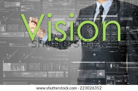 the businessman is writing Vision on the transparent board with some diagrams and infocharts with the dark elegant background