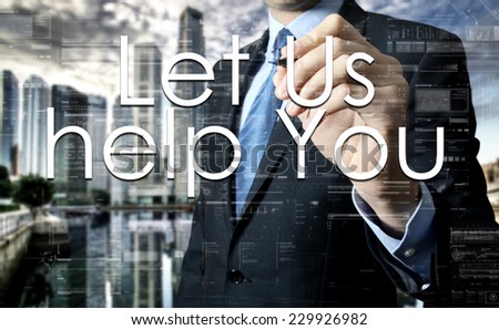 Businessman writing Let Us help You on virtual screen behind the back of the businessman one can see the city behind the window
