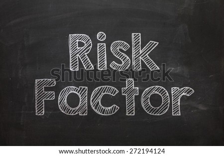 Text Risk Factor handwritten with white chalk on a blackboard