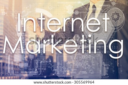 businessman writes on board text: Internet Marketing - with sunset over the city in the background, the visible sun\'s rays in a picture are symbolizing the positive attitude