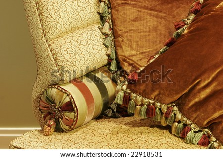 Close Up of Love Seat with Satin and Velvet Pillows Trimmed with Tassels