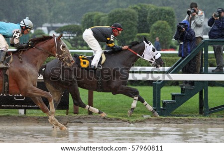 SARATOGA SPRINGS - JUL 23: Jockey Eibar Coa guides Cinder Cone through a downpour to victory in a claiming race at Saratoga Race Course on Jul 23, 2010 in Saratoga Springs, NY.