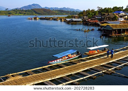 Traveler crossing bamboo bridge and play water in Sangklaburi Kanchanaburi country, Thailand