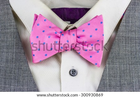 Close-up view of pink bow tie with white shirt and jacket