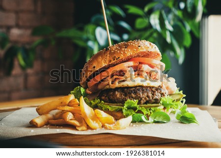 Beef Egg and Bacon Burger Served in Restaurant. American Food. Tasty Gourmet on Wooden Table.