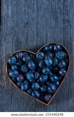 Fruit heart shape of blueberries from above on wooden background