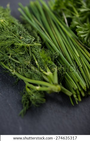 Spring garden fresh chives,parsley and dill on black slate  background
