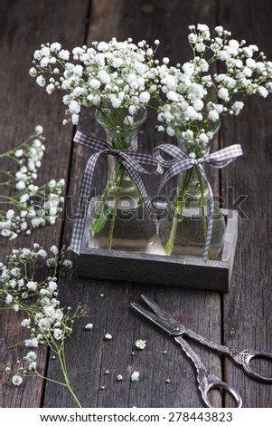 freshly cut wild meadow white flowers in mason jar on wooden rustic table
