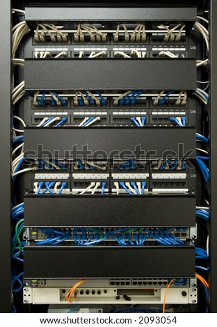 Patch cables plugged in to ethernet swicth and patch panel, in managed cabling rack