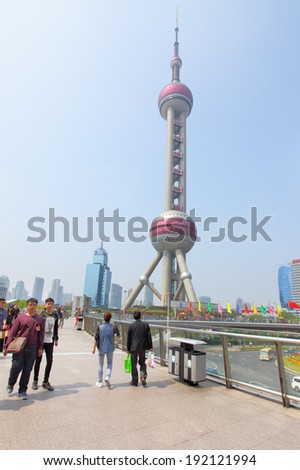 SHANGHAI, CHINA - APRIL 14, 2014: Oriental Pearl TV Tower and people on Shanghai Lujiazui flyover