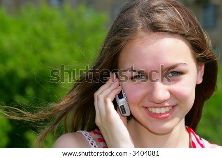 Young smiling girl with cell phone, background is out of focus