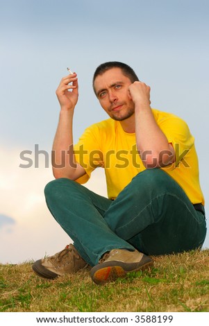 Man smoke and think, overcast sky in the background
