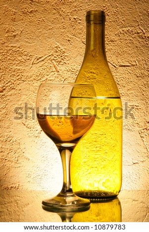 Still-life with white wine over yellow textured background