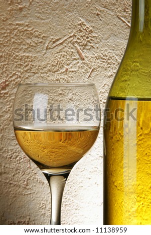 Still-life with white wine over textured background