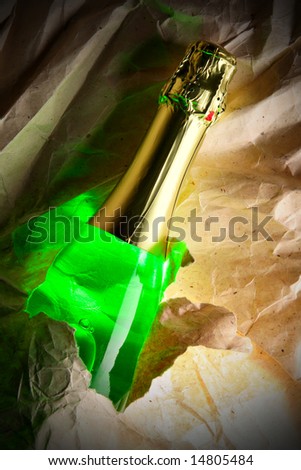Bottle of champagne and crumpled warping paper