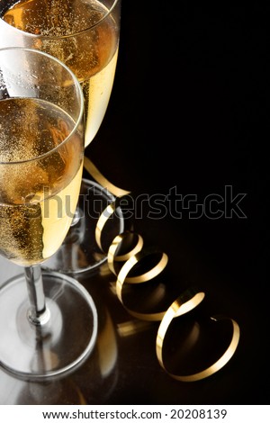 Couple glasses of champagne with gold streamer and space for your own text on right