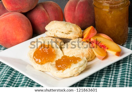 Fresh peach jelly on homemade biscuits with peaches