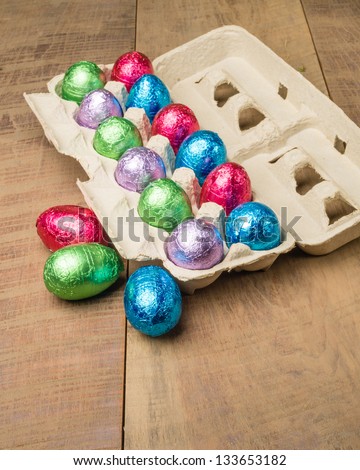 Colorful foiled chocolate eggs in egg container