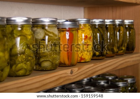 Canned goods on wooden storage shelves in pantry