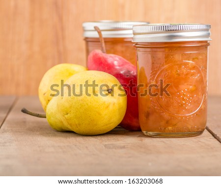 Pear jam in mason jars with red and yellow pears