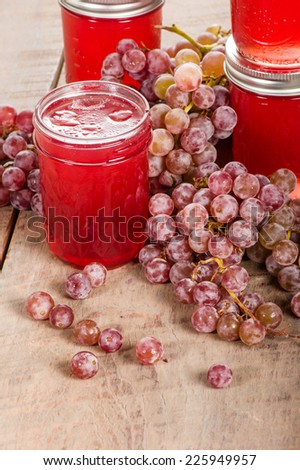 Pink grapes with jars of homemade jelly
