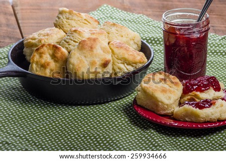 Cast iron skillet of fresh biscuits or scones with jam or jelly
