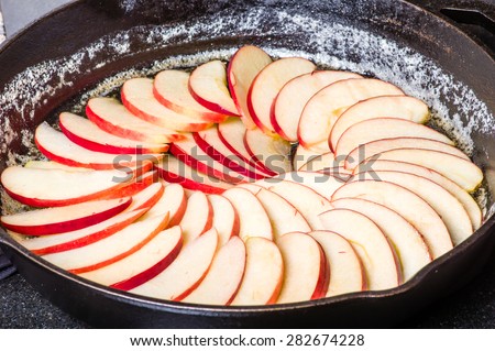 Apple slices arranged in skillet to make apple cake