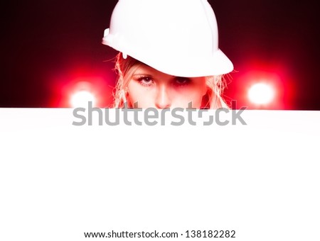 Young architect woman construction worker holding empty banner, glowing lights