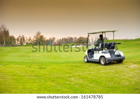 Young woman driving golf cart car on course to green