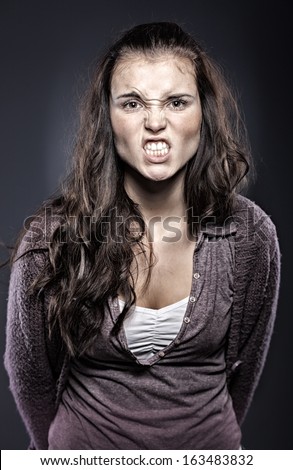 Very angry woman in fury on dark background