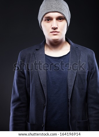 Portrait of a casual young man wearing jacket and cap