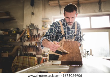 Similar – Image, Stock Photo Craftsman applying varnish to wood jalousie using airbrush in carpentry workshop