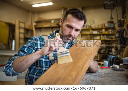Similar – Image, Stock Photo Craftsman applying varnish to wood jalousie using airbrush in carpentry workshop