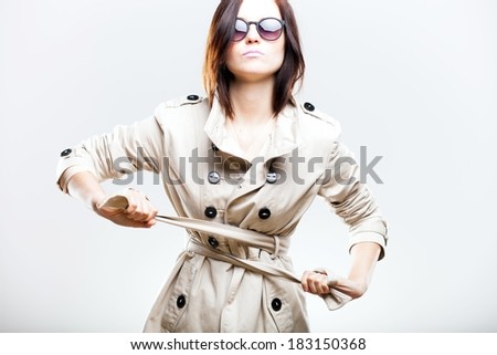 Fashion portrait of elegant woman in white coat with sunglasses