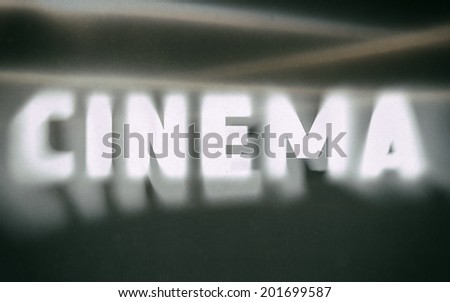Cinema word on vintage blurred background, concept sign
