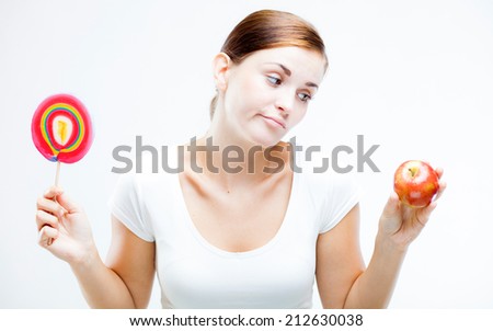 Woman choosing between sweets and fruits, healthy or unhealthy food concept