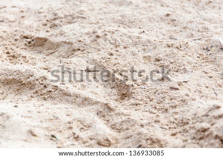 Sand background texture. Closeup of fresh raindrops on hot dry summer sand, Mediterranean beach in July.