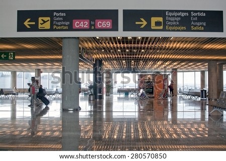 AIRPORT, PALMA DE MALLORCA, SPAIN - APRIL 24, 2015: Airport interior with information signs and people reflected in shiny floor surface on April 24, 2015 in Palma de Mallorca, Balearic islands, Spain.