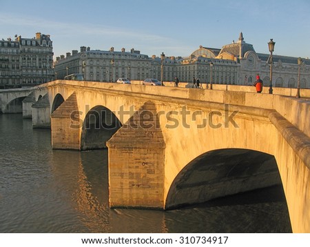 PARIS, FRANCE - JANUARY 3, 2010: Paris bridge crossing the river Seine in morning sunlight from the right bank on January 3, 2010 in Paris, France.