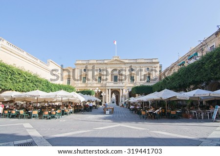 VALLETTA, MALTA - SEPTEMBER 15, 2015: Caffe Cordina outdoor restaurant and cafe and the National Library classical baroque building on a sunny day in September 15, 2015 in Valletta, Malta.