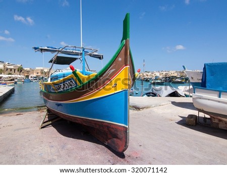 MARSAXLOKK, MALTA - SEPTEMBER 15, 2015: Colorful painted wood boat with the typical protective eye on a sunny day in September 15, 2015 in Marsaxlokk, Malta.