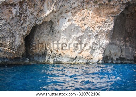 Limestone rocks with caves and clear turquoise water of popular tourist attraction Blue Grotto on a sunny day in September 15, 2015 in Malta.