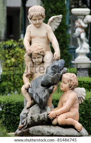 The statue of Cupid in the garden.