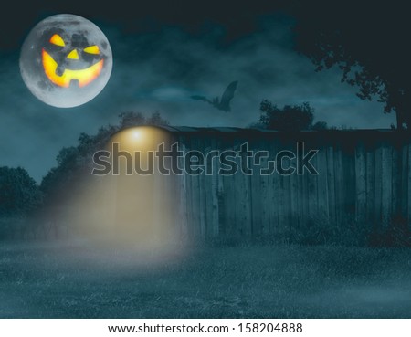 Halloween theme with smiling moon looking at open barn with light