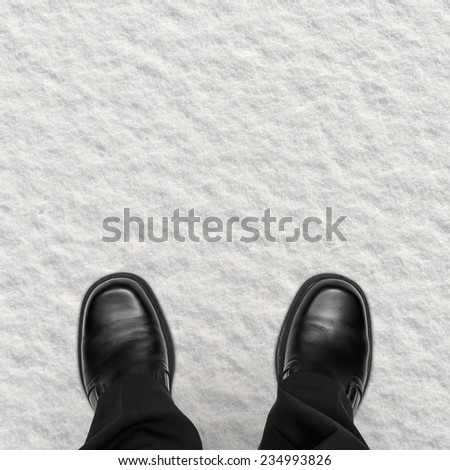 Business man shoes in snow, overhead view