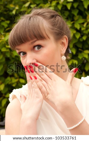 Portrait of a surprised young woman with hands over her mouth