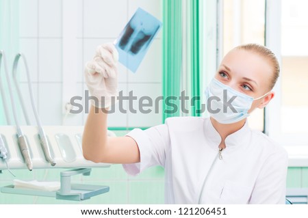 woman doctor in protective mask looking at x-ray, protection of health
