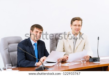 two businessmen sitting in a chair at the table, talk at the conference